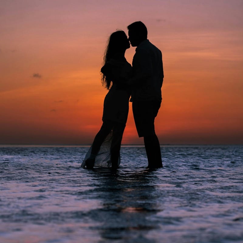 Romantic couple kissing in a passionate embrace outdoor date